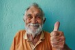 © Markus Schröder - Portrait of a content man in his 80s showing a thumb up in soft teal background