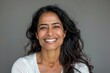 © Markus Schröder - Portrait of a grinning indian woman in her 30s smiling at the camera over soft gray background