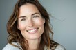 © Markus Schröder - Portrait of a happy caucasian woman in her 40s smiling at the camera in soft gray background