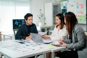 Poster - Asian entrepreneurs working together in a modern office, analyzing financial charts and reports displayed on a laptop