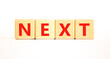 © Dzmitry - Next symbol. Concept word Next on beautiful wooden blocks. Beautiful white table white background. Business, lifestyle, support and next concept. Copy space.