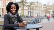 © imagineRbc - A woman with curly hair smiles while sitting at a table in a lively city square. She holds a cup of coffee, surrounded by historic buildings and bicycles, enjoying a beautiful day