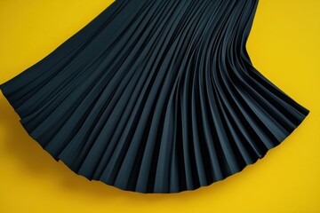 Fototapete - Black pleated fabric draped elegantly over a vibrant yellow surface showcasing texture and design