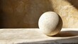 © harryaishi - Stone sphere on light beige surface.