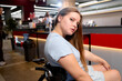 © luengo_ua - Young Woman in Wheelchair in a Cozy Café Setting