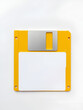 © Kyle - Yellow floppy disk with blank label on white background. Magnetic means of storing information.