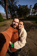 © asier - Cheerful couple capturing smartphone selfie during stroll through picturesque cobblestone streets of combarro, galician coastal village, celebrating travel moments under bright sunlight