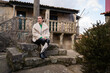 © asier - Tourist relaxing on stone steps in picturesque combarro, galicia, absorbing coastal charm and traditional architectural details of historic spanish village