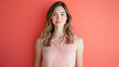 © Oppilamani - A woman in her late 20s standing with a proud posture, highlighting her sculpted physique in a sleeveless shirt, against a solid coral background