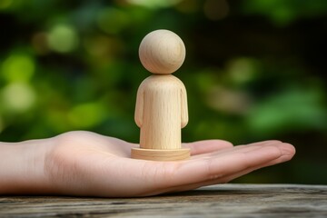 Fototapete - Wooden man figure on a wooden pedestal with human hand, business concept