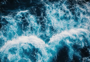 Poster - Aerial view of dynamic ocean waves with white foam, turquoise waters, and deep blue hues reflecting sunlight in a serene coastal landscape