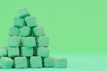 Poster - Green Sugar Cubes Stacked in a Creative Arrangement on a Vibrant Background
