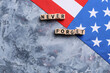 © Pixel-Shot - Wooden blocks with inscription in memory of  National Day of Prayer and Remembrance for the Victims of the Terrorist Attacks on blue background