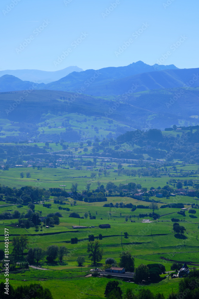 Breathtaking green valley opening up to blue mountains in rural landscape
