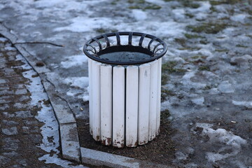 Poster - A trash can sitting on the side of a road.