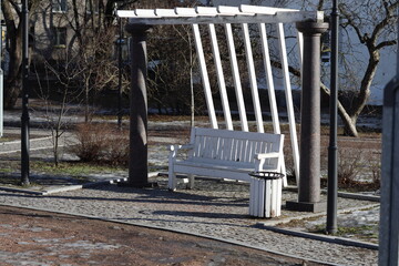Aufkleber - A simple wooden bench under a pergola structure, suitable for outdoor use.