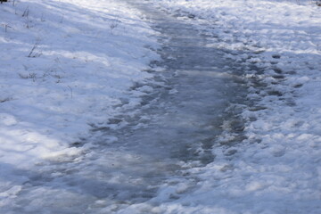 Poster - A stream runs through a snowy field with winter scenery, suitable for use in winter-themed presentations and designs.