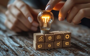 Aufkleber - Closeup of a womans hand interacting with a glowing light bulb on a wooden block inscribed with Ideas