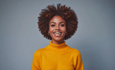 Poster - Woman with curly hair is smiling and wearing a yellow sweater. She looks happy and confident. The sweater is a bright and cheerful color that complements her natural beauty