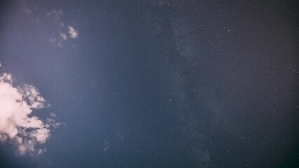 Wall Mural - Cloudy Night Starry Sky With Glowing Stars. Bright Glow Of Sky Stars And Milky Way Galaxy. 4K. Natural Background Backdrop. time lapse, timelapse, time-lapse