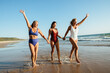 © (JLco) Julia Amaral - Three women enjoying a joyful day walking on the beach in swimsuits