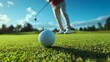 © Aodsy - Golf Ball on Green with Player Preparing for Shot in Bright Sunlight