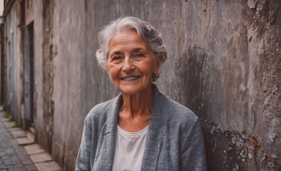 Poster - Woman with gray hair is smiling and standing in front of a wall. She is wearing a gray jacket and a white shirt