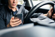 © terovesalainen - Driving distracted by phone. Car driver texting. Accident and crash danger. Man using mobile cellphone while on road. Irresponsible guy using text sms. No safety. Rideshare app in smartphone.