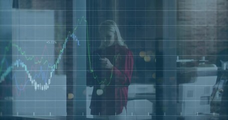 Wall Mural - Using smartphone, person viewing animation of financial data charts in office