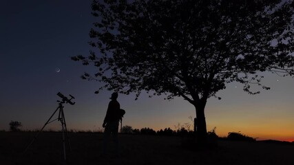Wall Mural - amateur astronomer looking at the evening skies, observing planets, stars, moon and other celestial 