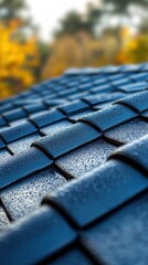 Poster - Close up of wet blue roof tiles after rain with blurred autumn foliage in the background creating a serene and peaceful atmosphere perfect for roofing and construction