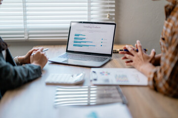 Poster - Businesswomen discussing over trending products data displayed on laptop during a business meeting