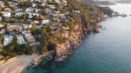 Wall Mural - This stunning aerial view highlights beautiful homes on a cliffside along a peaceful beach. The coastal landscape and crystal-clear ocean create a serene environment.