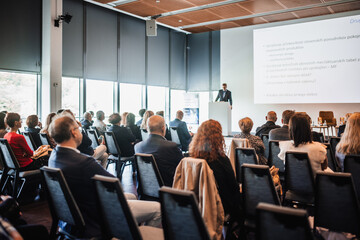 Wall Mural - speaker giving a talk in conference hall at business event. rear view of unrecognizable people in au