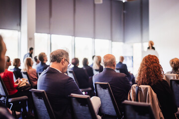 Wall Mural - business and entrepreneurship symposium. female speaker giving a talk at business meeting. audience 
