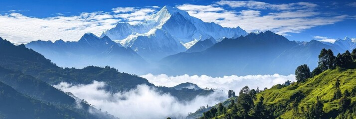 Leinwandbilder - Stunning view of snow capped mountains over lush green hills and misty valleys under an expansive sky
