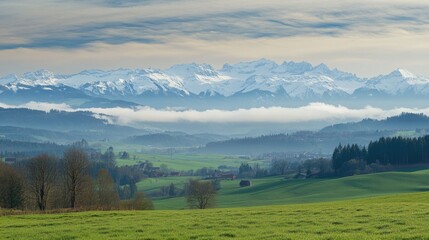Leinwandbilder - Scenic view of snow capped mountains with mist and green hills under an expansive sky