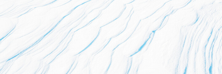 Wall Mural - wide panoramic winter background with snowy ground. natural snow texture. wind sculpted patterns on 