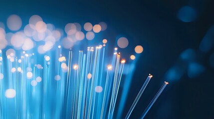 Poster - Glowing blue fiber optic cables with soft bokeh light effects against dark background create modern technology and communication concept.