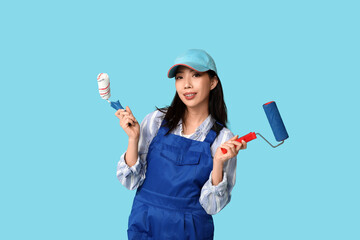 Wall Mural - female asian painter with rollers on blue background