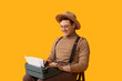 © Pixel-Shot - Young man working with vintage typewriter on chair against yellow background