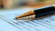 © Get it - Close-up of gold pen resting on a document, showcasing fine details and a shallow depth of field