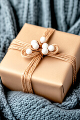Wall Mural - brown box with white flowers tied to it is sitting on a blue blanket. the box is wrapped in a brown 