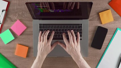 A person types program code in the CSS programming language in the office