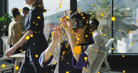 Poster - In office, person using VR headset with glowing orange particles animation