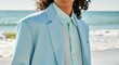 © Passion - Young hispanic male in light blue suit standing near ocean shore