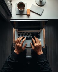 Poster - a person working on a laptop with a cup of coffee, stationary on a table, top view shot