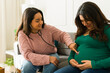 © AntonioDiaz - Female physician listening with stethoscope, examining pregnant woman's abdomen during healthcare visit, ensuring maternal and fetal wellness