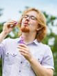 © Voyagerix - Man blowing soap bubbles, having fun