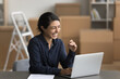 © fizkes - Candid laugh. Smiling joyful young girl wholesale warehouse worker postal delivery service sales manager cargo transportation company employee having fun at workplace desk looking on notebook screen